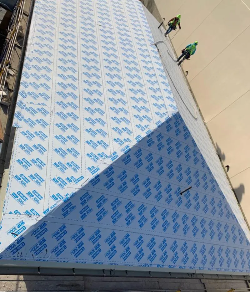 Professional roofers installing underlayment on a metal roof in Crescent City